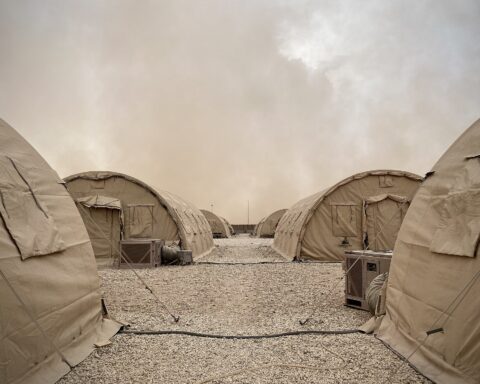Military tents at Prince Sultan Air Base in Saudi Arabia under a desert haze sky, the primary US forward operating base 27 kilometers from Al-Kharj