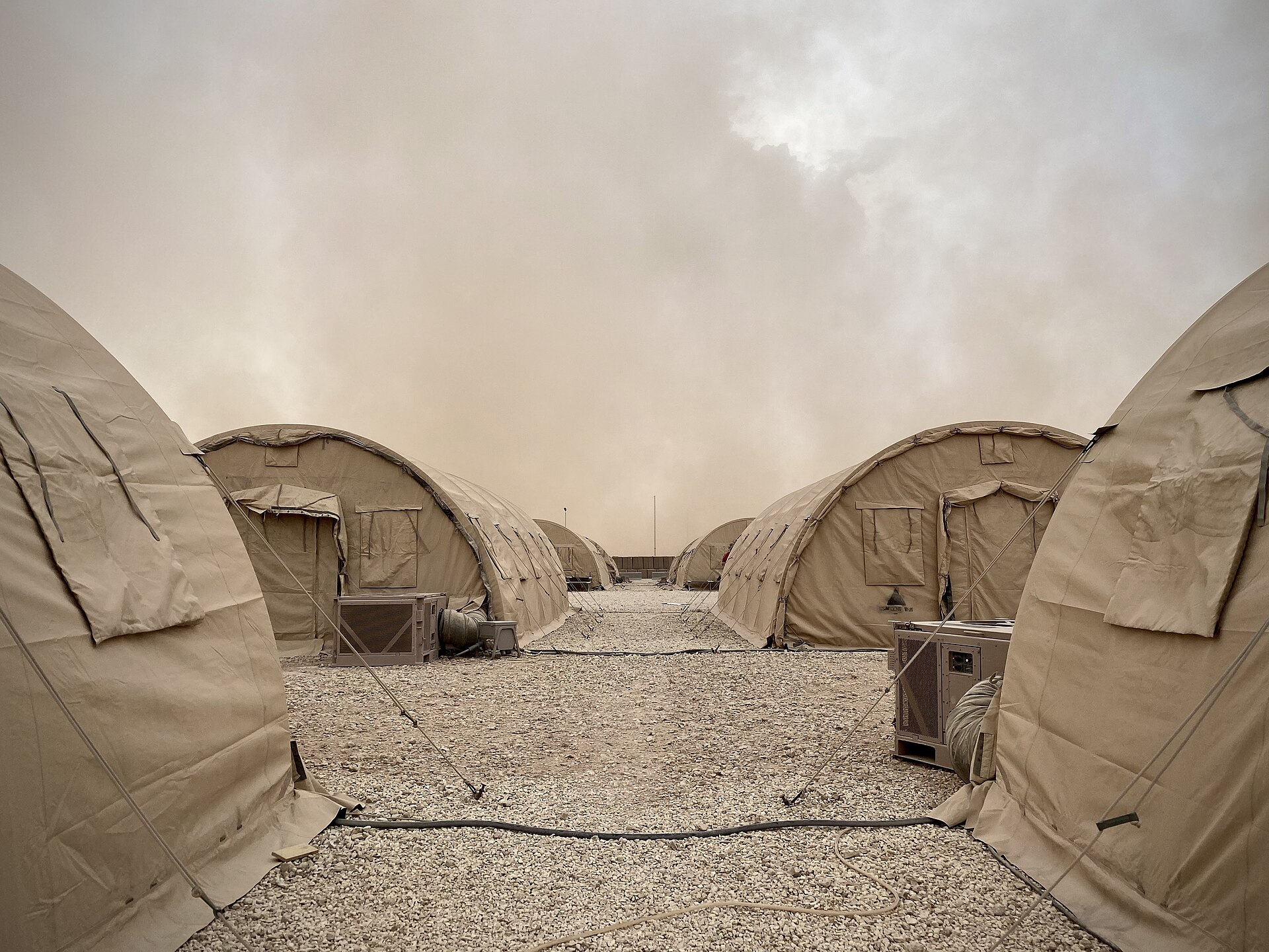 Military tents at Prince Sultan Air Base in Saudi Arabia under a desert haze sky, the primary US forward operating base 27 kilometers from Al-Kharj