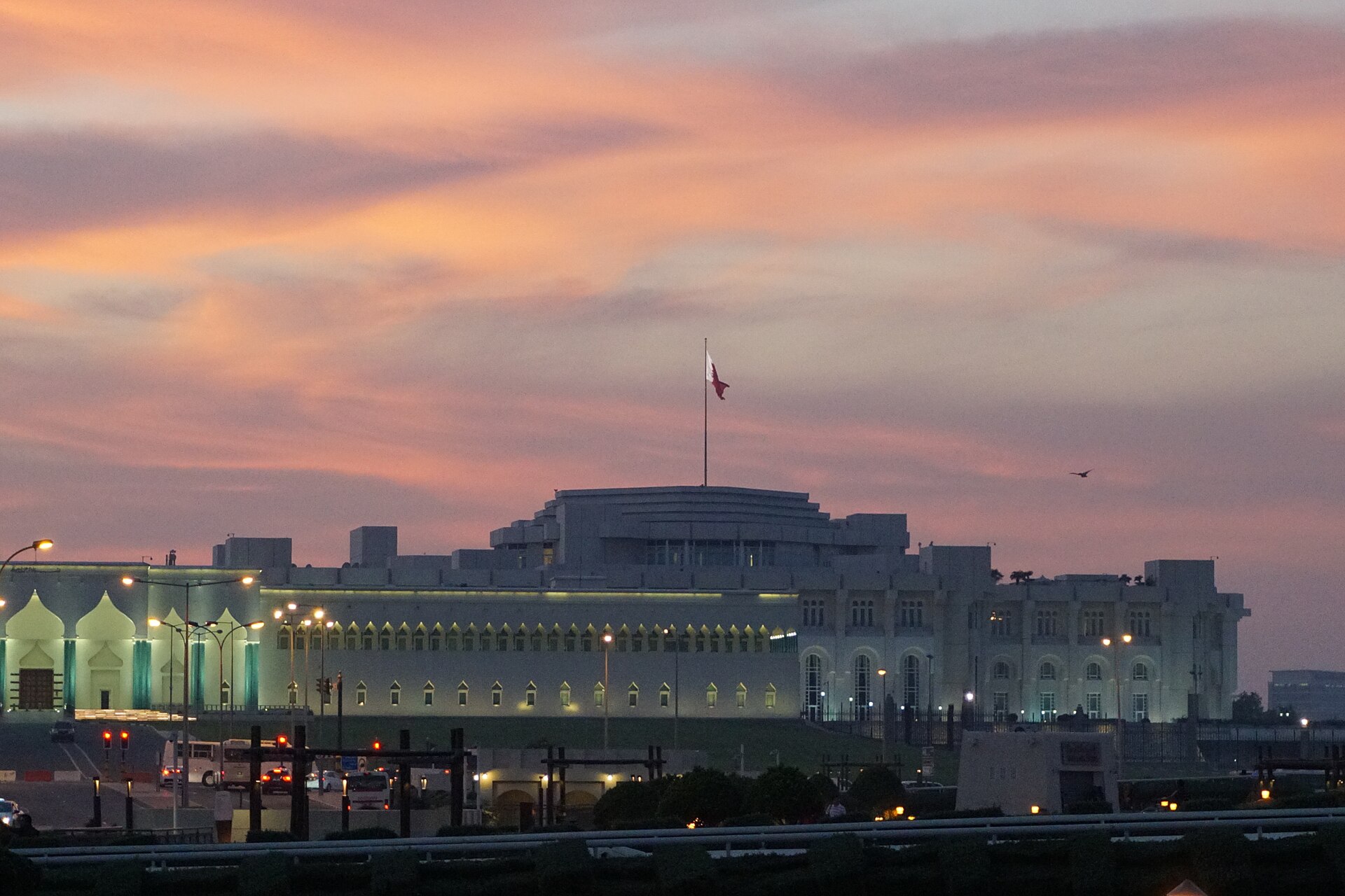 Qatar Amiri Diwan government seat Doha at dusk with Qatari flag