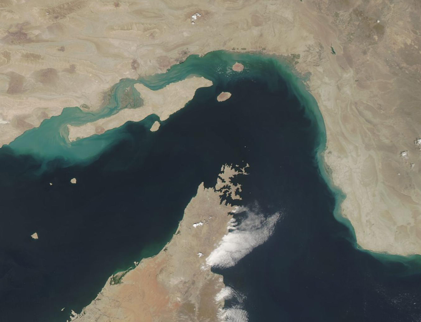 NASA MODIS satellite image of Qeshm Island and the Strait of Hormuz — Iran's arrow-shaped largest island sits at the heart of the 21-mile chokepoint controlling 21 percent of global oil supply