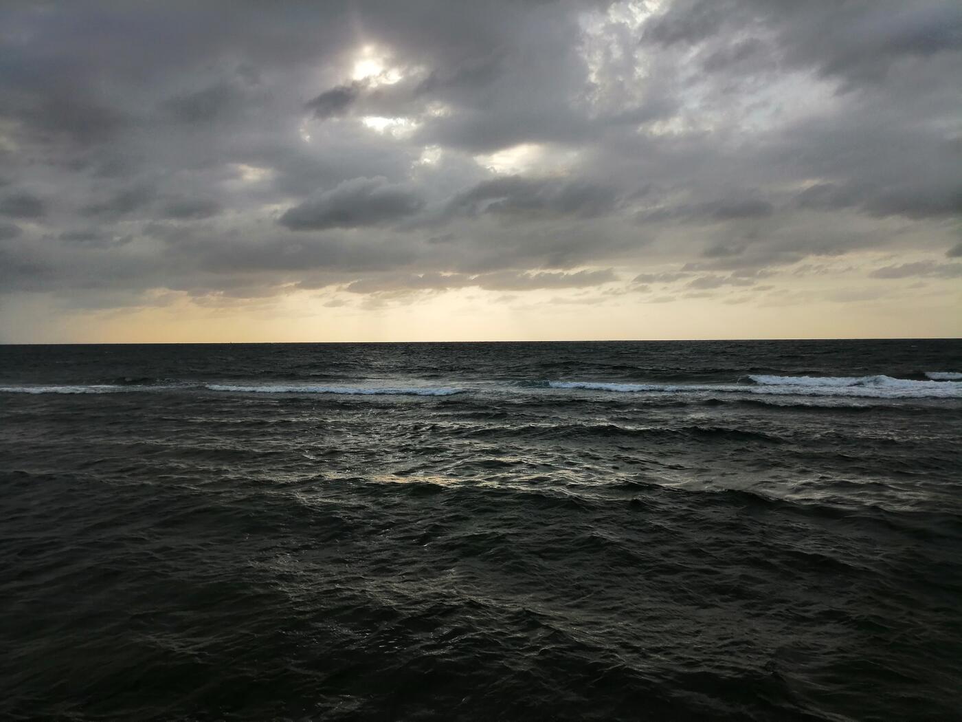 Red Sea waves breaking along the Jeddah coast with dramatic cloud formations overhead