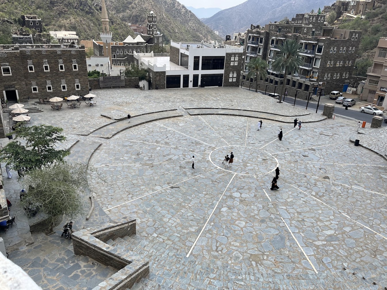 Rijal Almaa central plaza with visitors and surrounding mountain heritage buildings