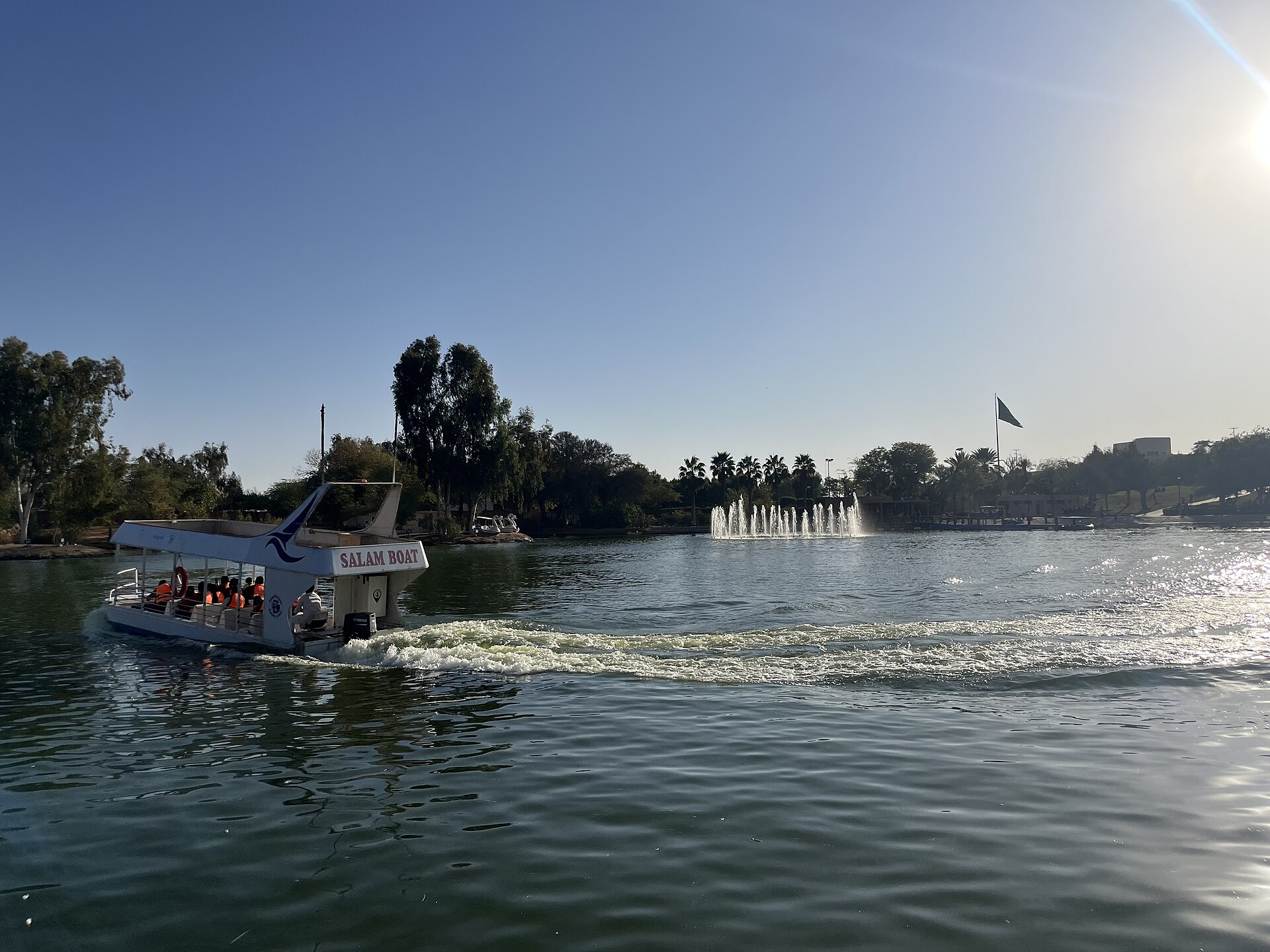 Shuttle boat crossing the artificial lake at Salam Park in Riyadh with fountain spraying in the background