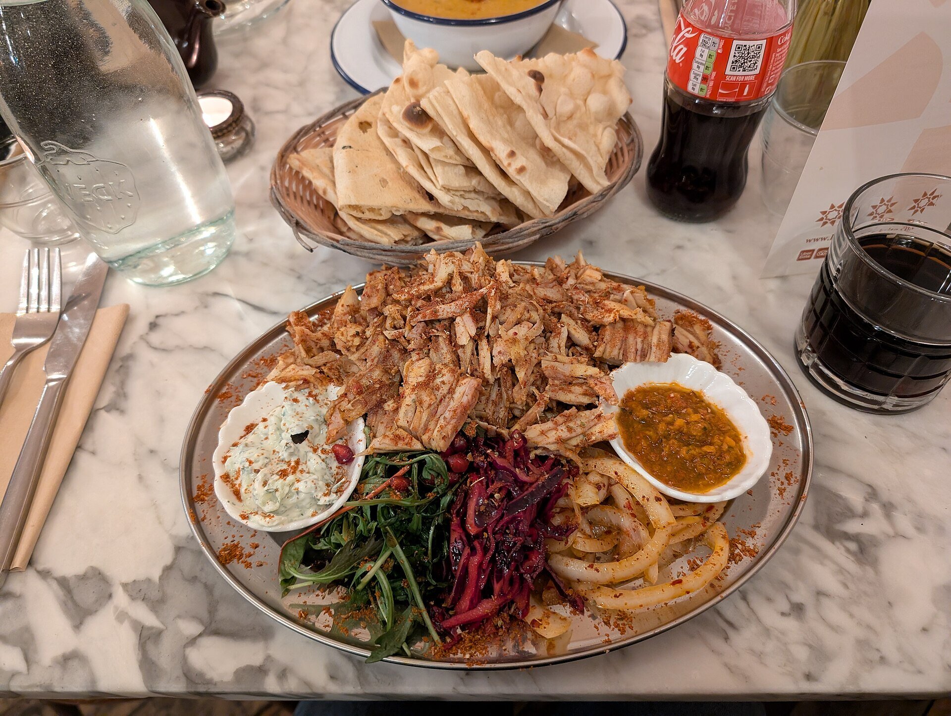 Chicken shawarma platter with garlic sauce, pickles, and Arabic bread served in Riyadh