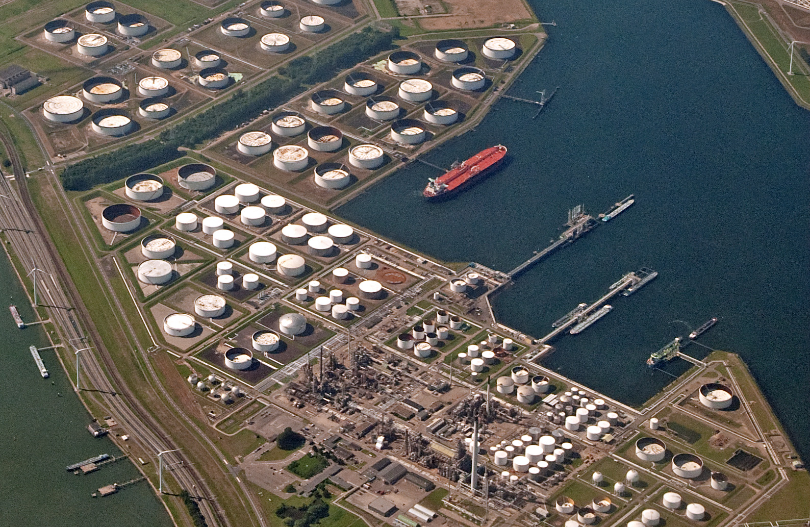 Aerial view of Europort petroleum storage terminal in Rotterdam showing crude oil storage tanks, refinery infrastructure, and tanker berths