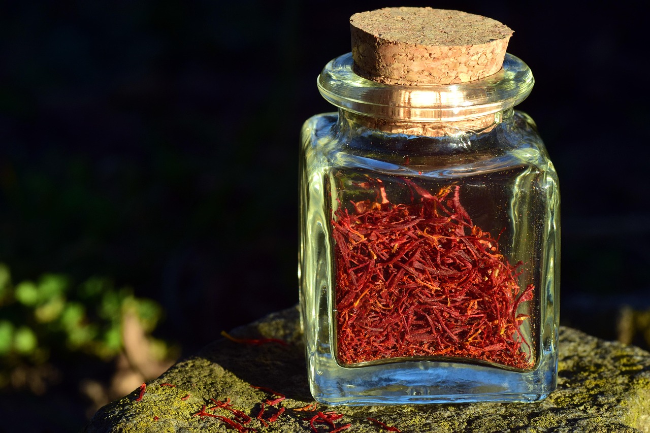 Deep red saffron threads in a glass jar with cork stopper