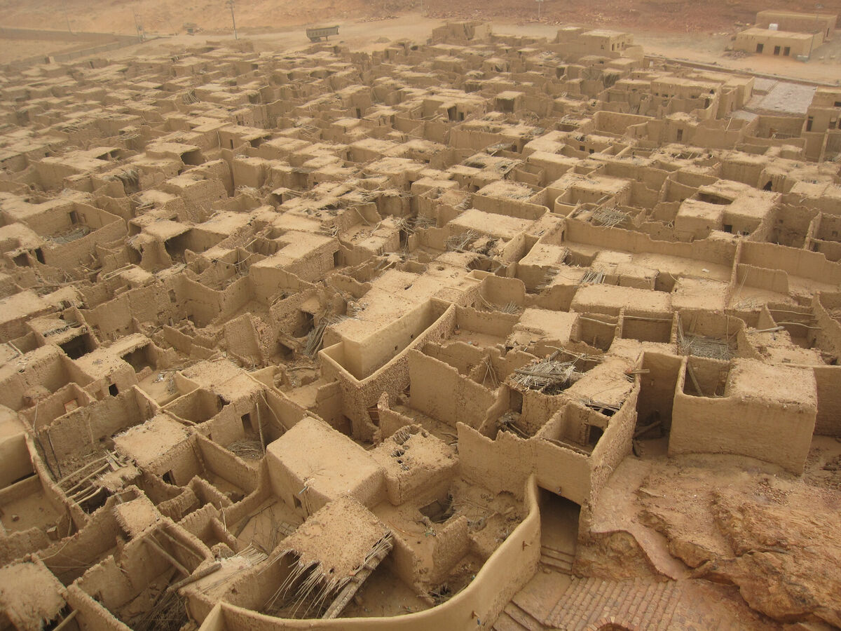 View of the old town of AlUla, Saudi Arabia, with traditional stone buildings set against a dramatic sandstone landscape