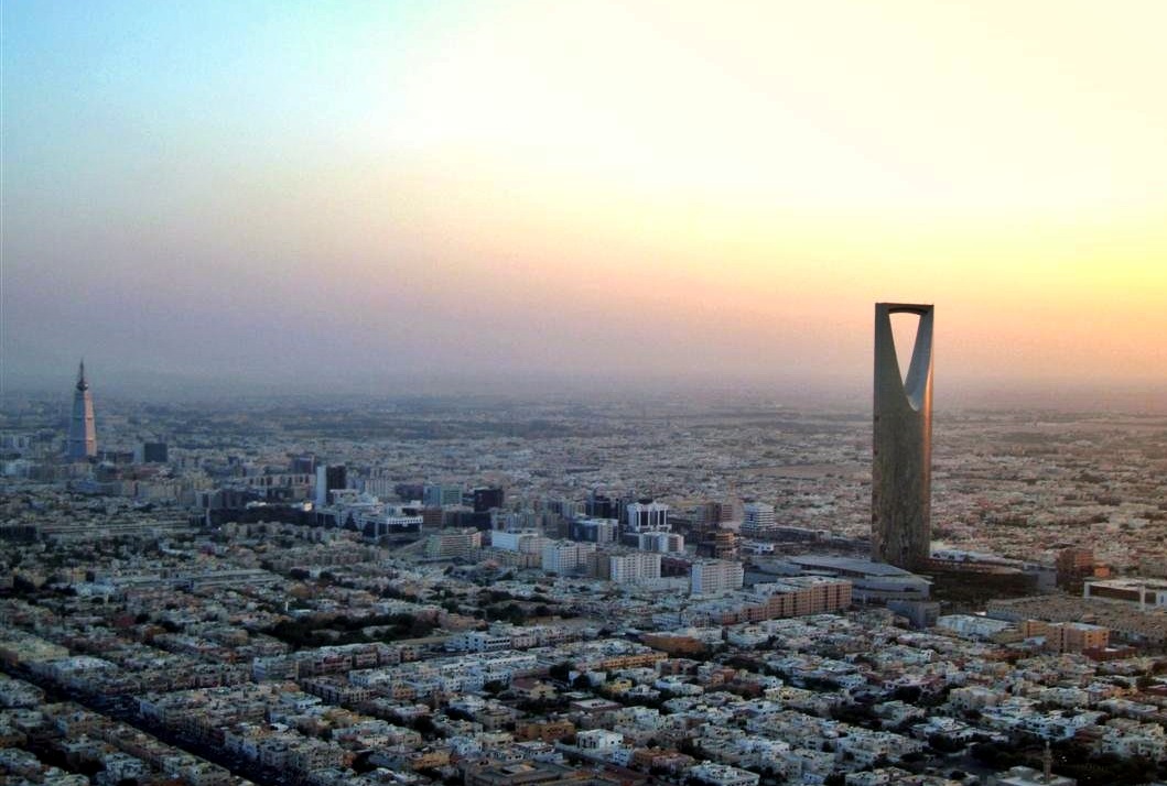 Riyadh skyline at sunset with the Kingdom Tower and Faisaliyah Tower visible across the cityscape