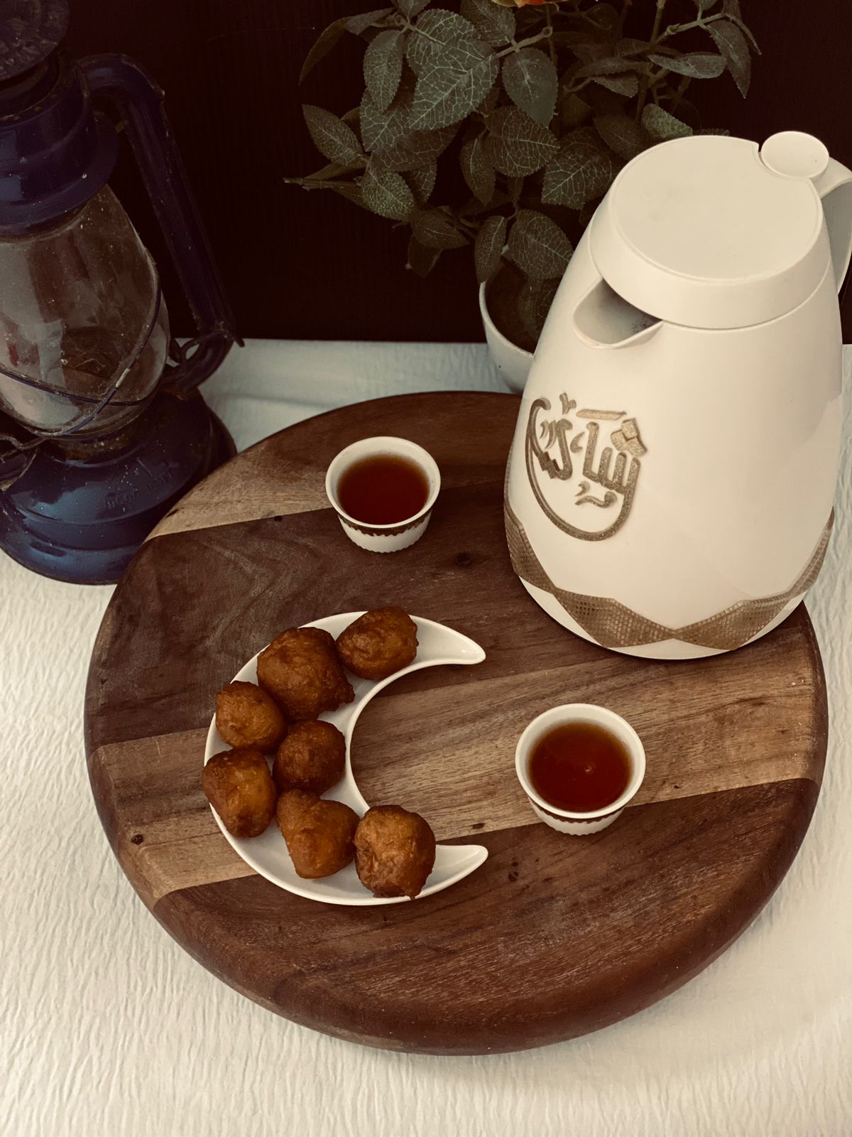 Luqaimat sweet dumplings served on a crescent-shaped plate with Arabic coffee