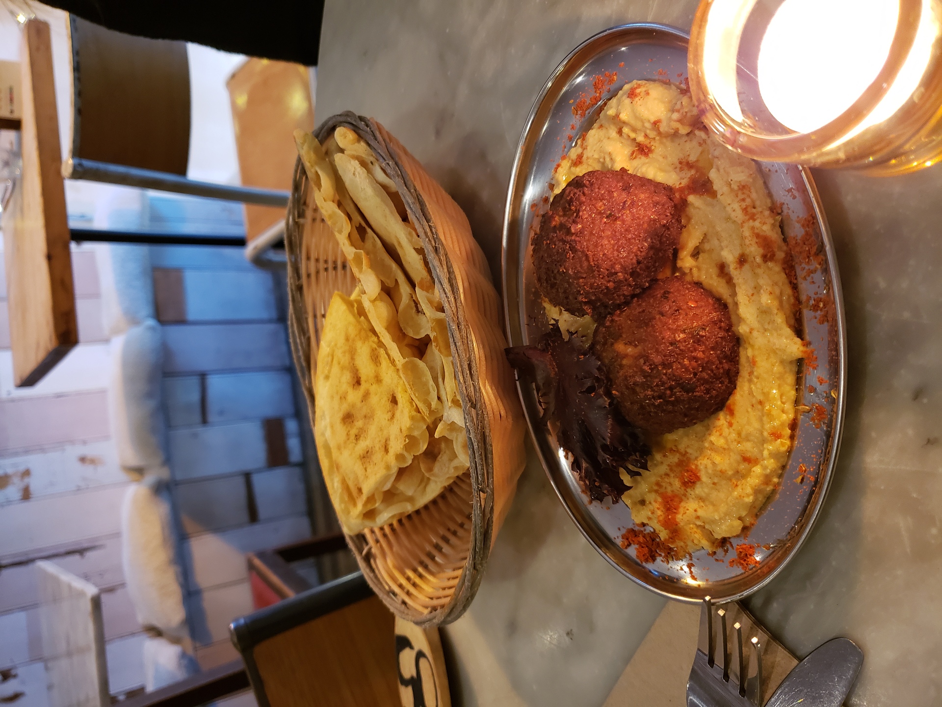 A plate of falafel served on a bed of hummus with flatbread, a classic vegan meal in Saudi Arabia