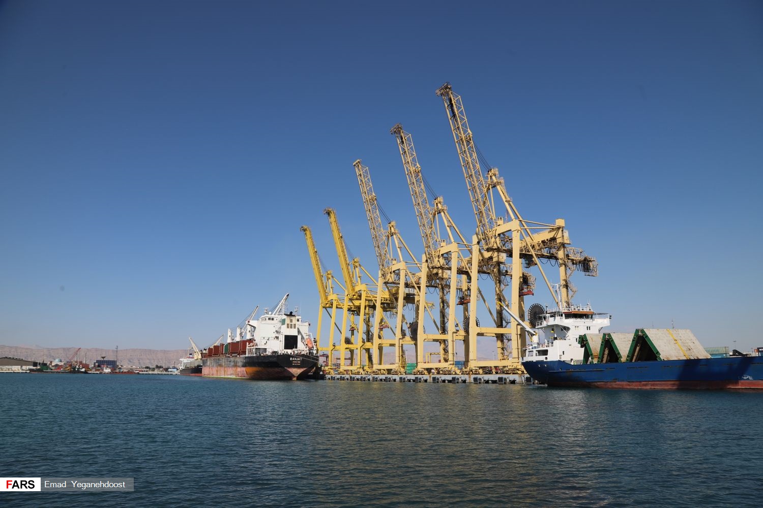 Shahid Rajaei port gantry cranes and bulk cargo vessels at Bandar Abbas — Iran's dominant container gateway accounting for 55% of total national trade volume