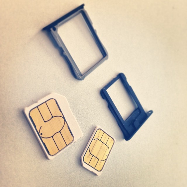 Micro SIM and nano SIM cards with smartphone SIM trays, showing the two card sizes used in modern phones