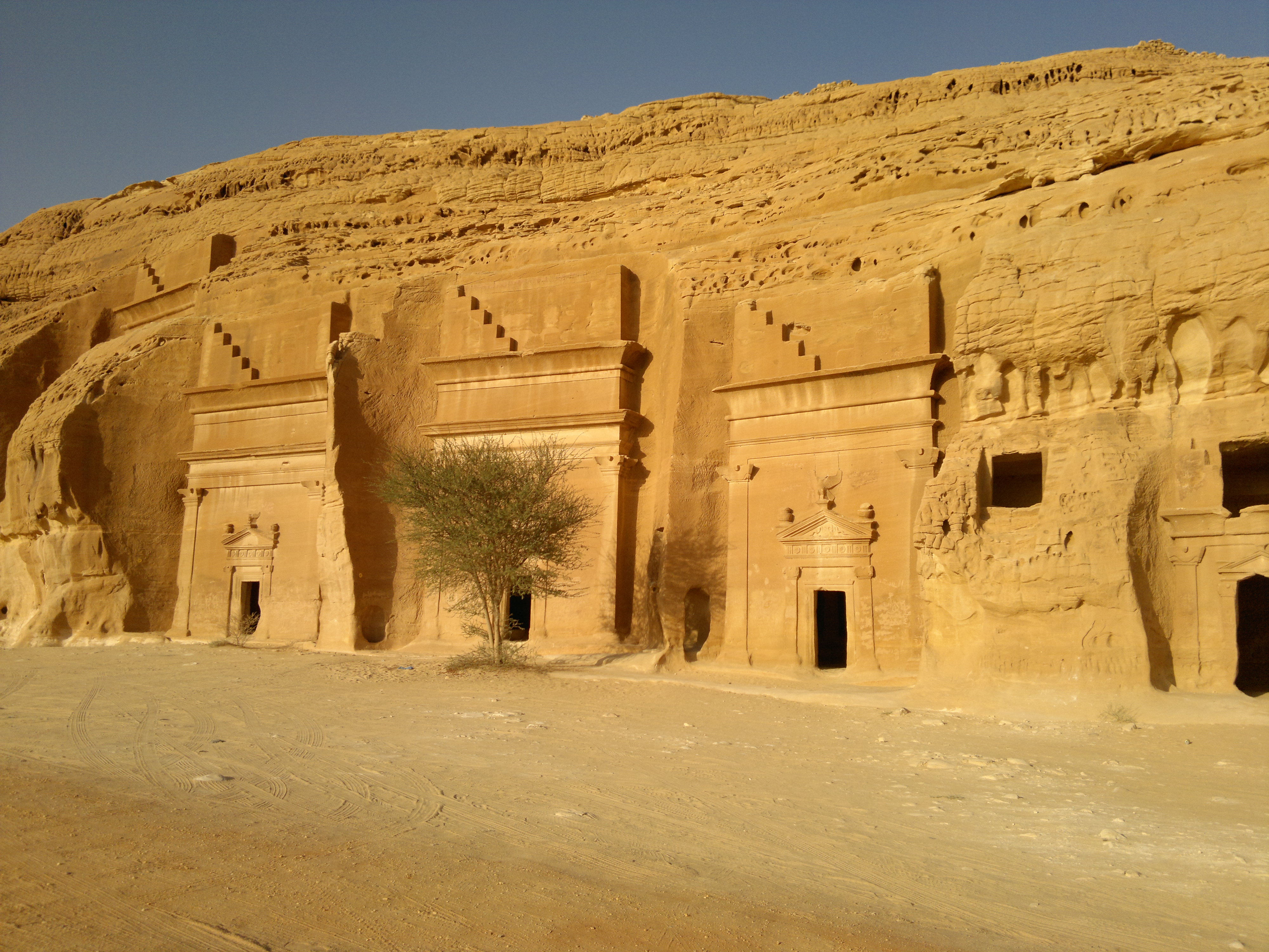 Ancient rock-cut Nabataean tombs carved into sandstone cliffs at Hegra in AlUla, Saudi Arabia