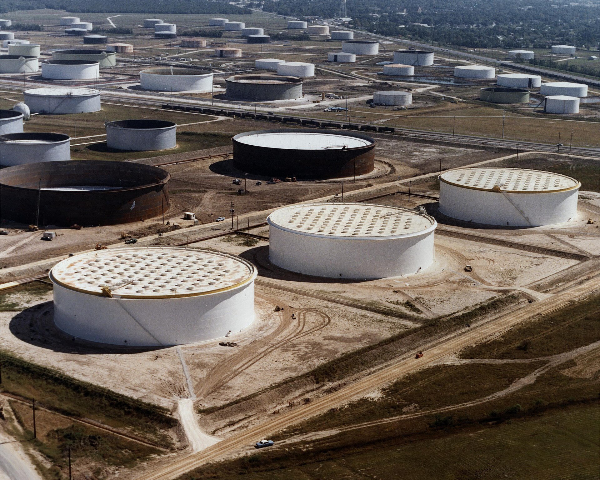 Aerial view of US Strategic Petroleum Reserve crude oil storage tanks at the Sunoco terminal in Nederland, Texas, showing dozens of large white cylindrical tanks