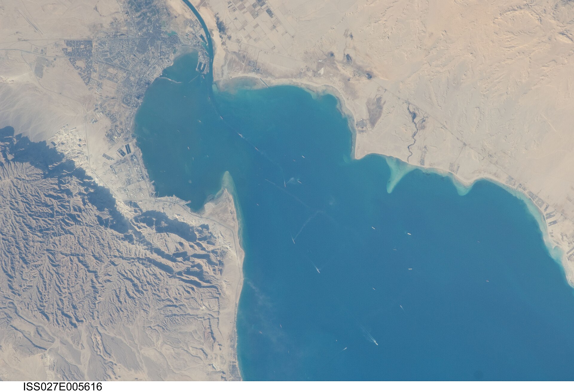 ISS satellite view of the northern Suez Canal entrance, Port Said, and the Great Bitter Lake — Egypt controls this waterway whose $449 million monthly revenue depends on stable maritime corridors through both Hormuz and Bab el-Mandeb