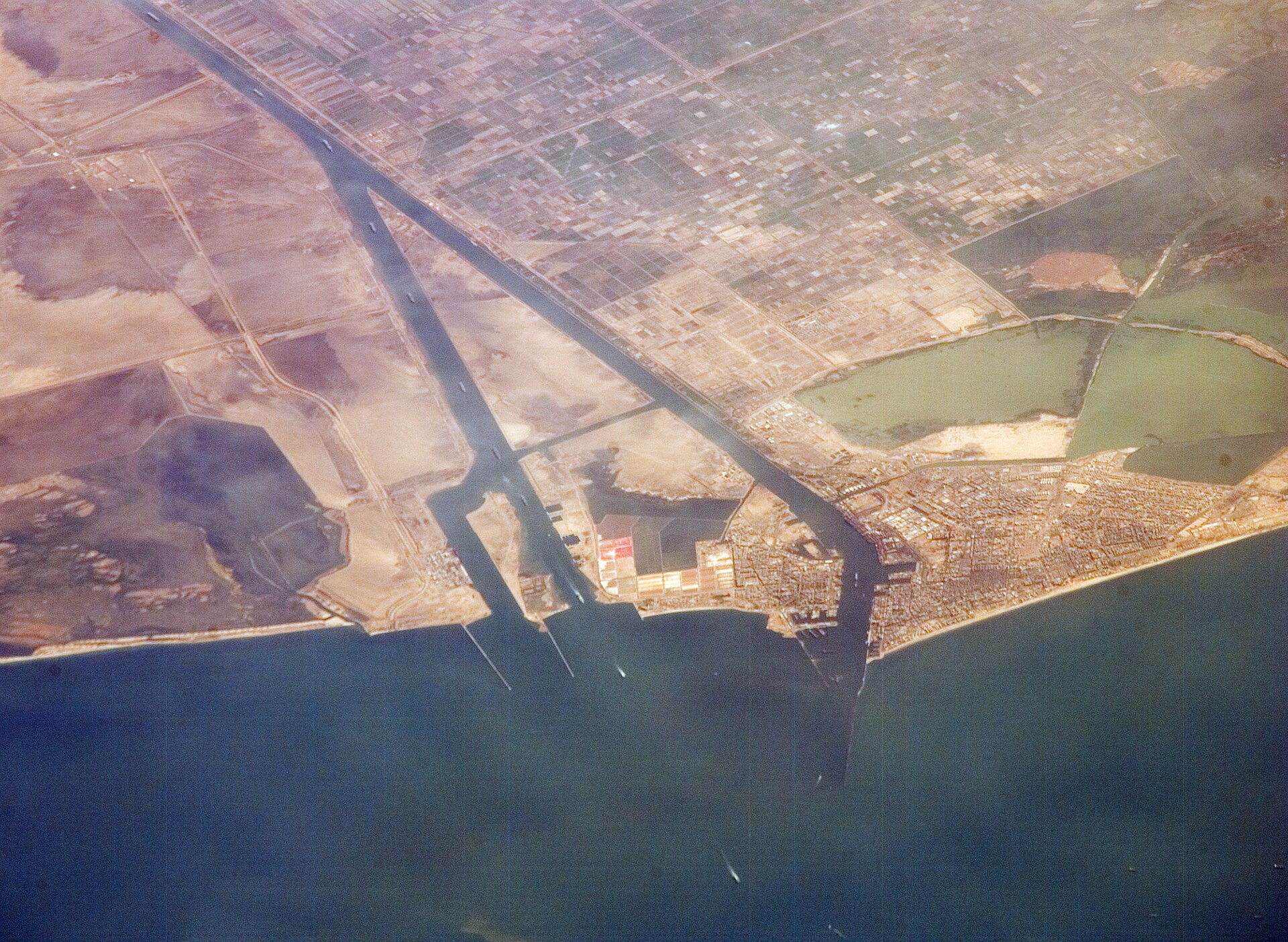 Suez Canal at Port Said photographed from the International Space Station — Egypt's canal revenue fell from a peak of $10.25 billion in FY2023 to a projected $3.6 billion, driving Cairo's ceasefire extension stake