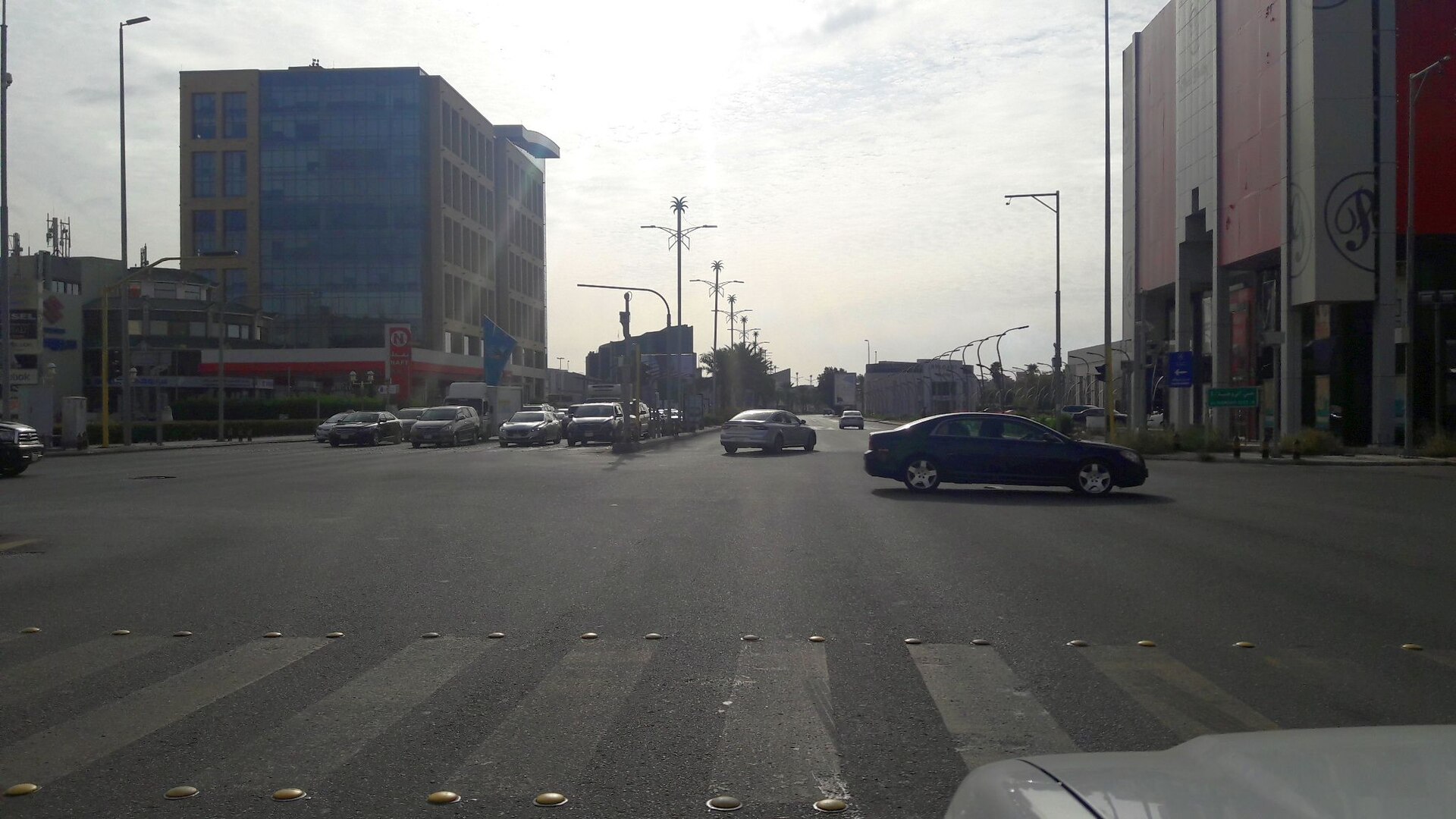 Street-level view of Tahlia Street in Jeddah with commercial buildings and traffic