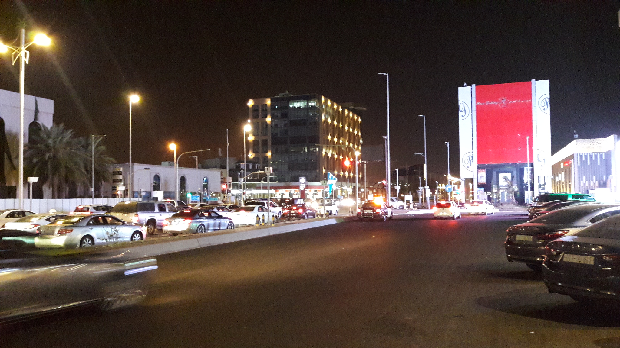 Tahlia Street in Jeddah illuminated at night with traffic and lit storefronts