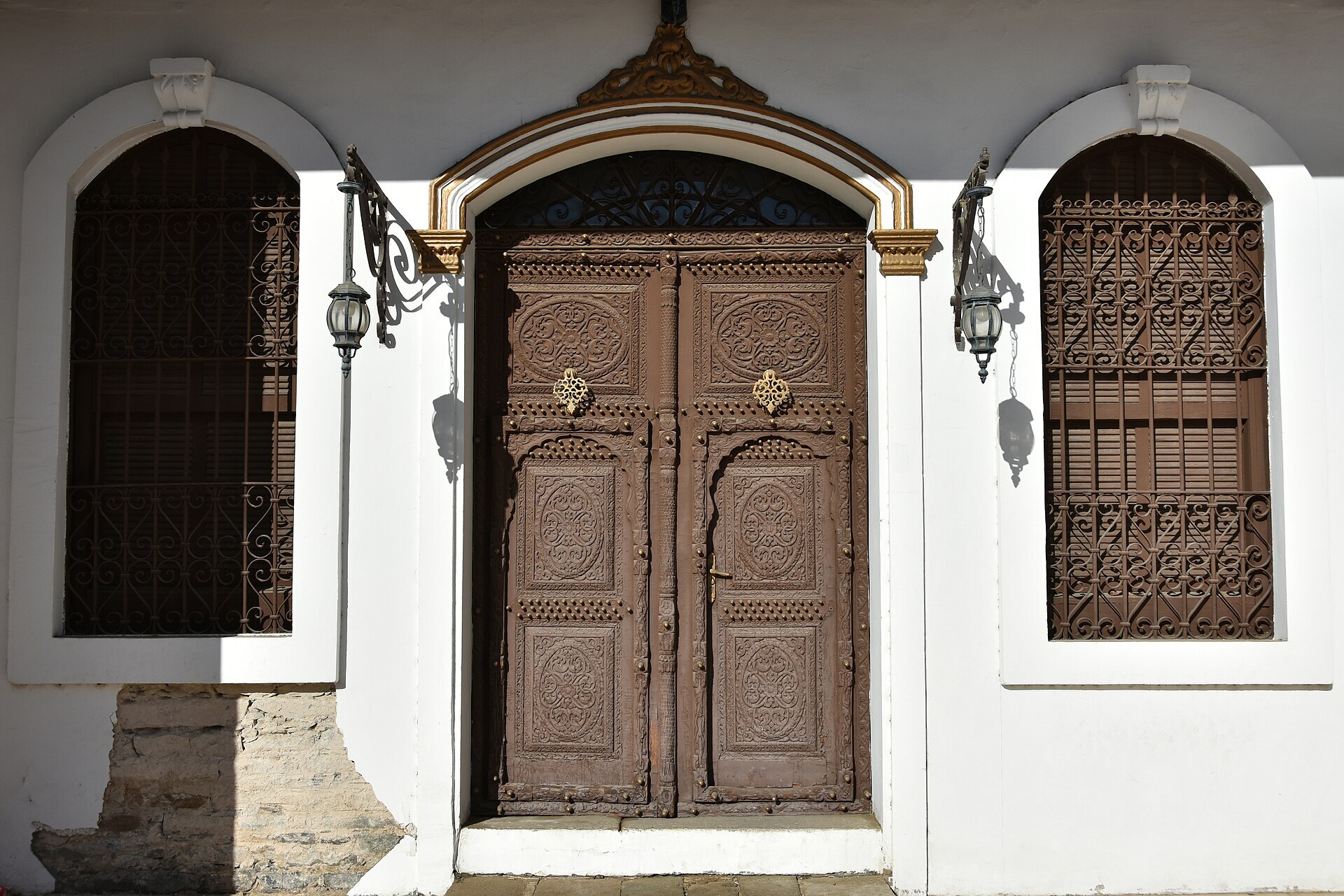 Ornate carved wooden entrance door and iron-lattice windows of Shubra Palace in Taif, Saudi Arabia