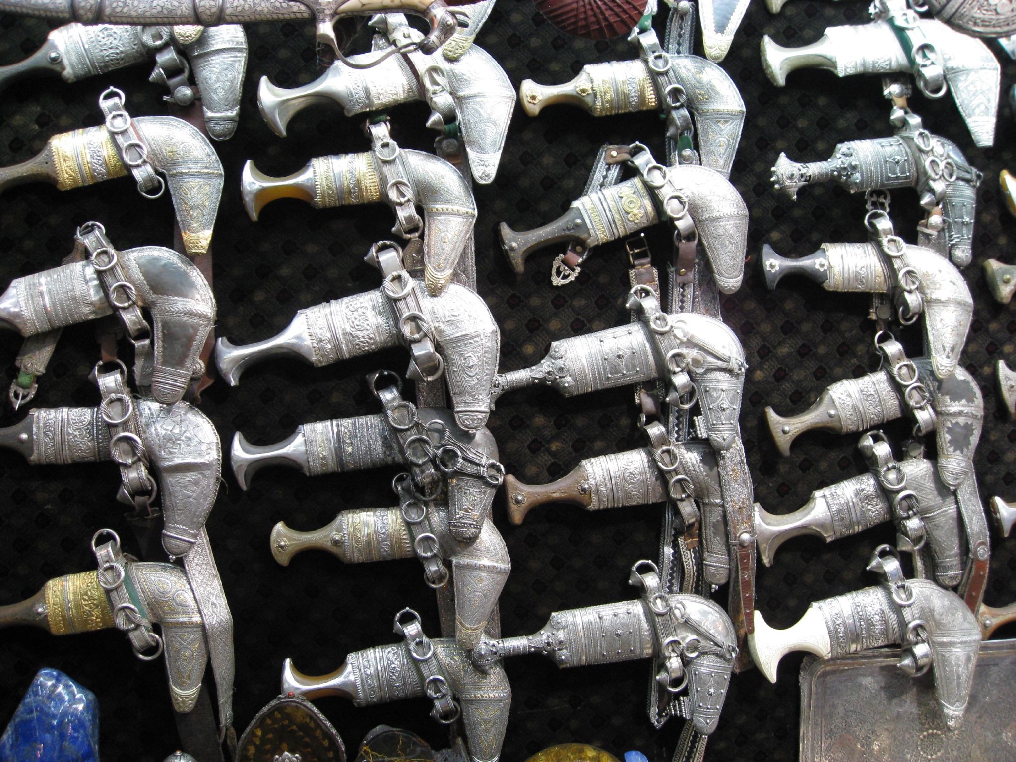 Traditional silver khanjar daggers displayed for sale in a Gulf souk, showing intricate metalwork craftsmanship