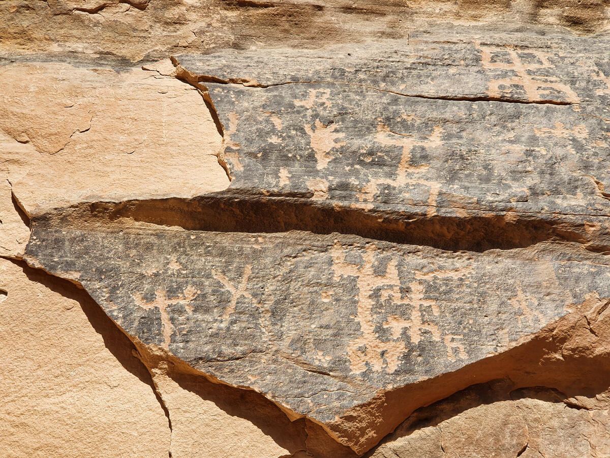 Petroglyphs depicting human figures carved into grey rock at AlUla in western Saudi Arabia