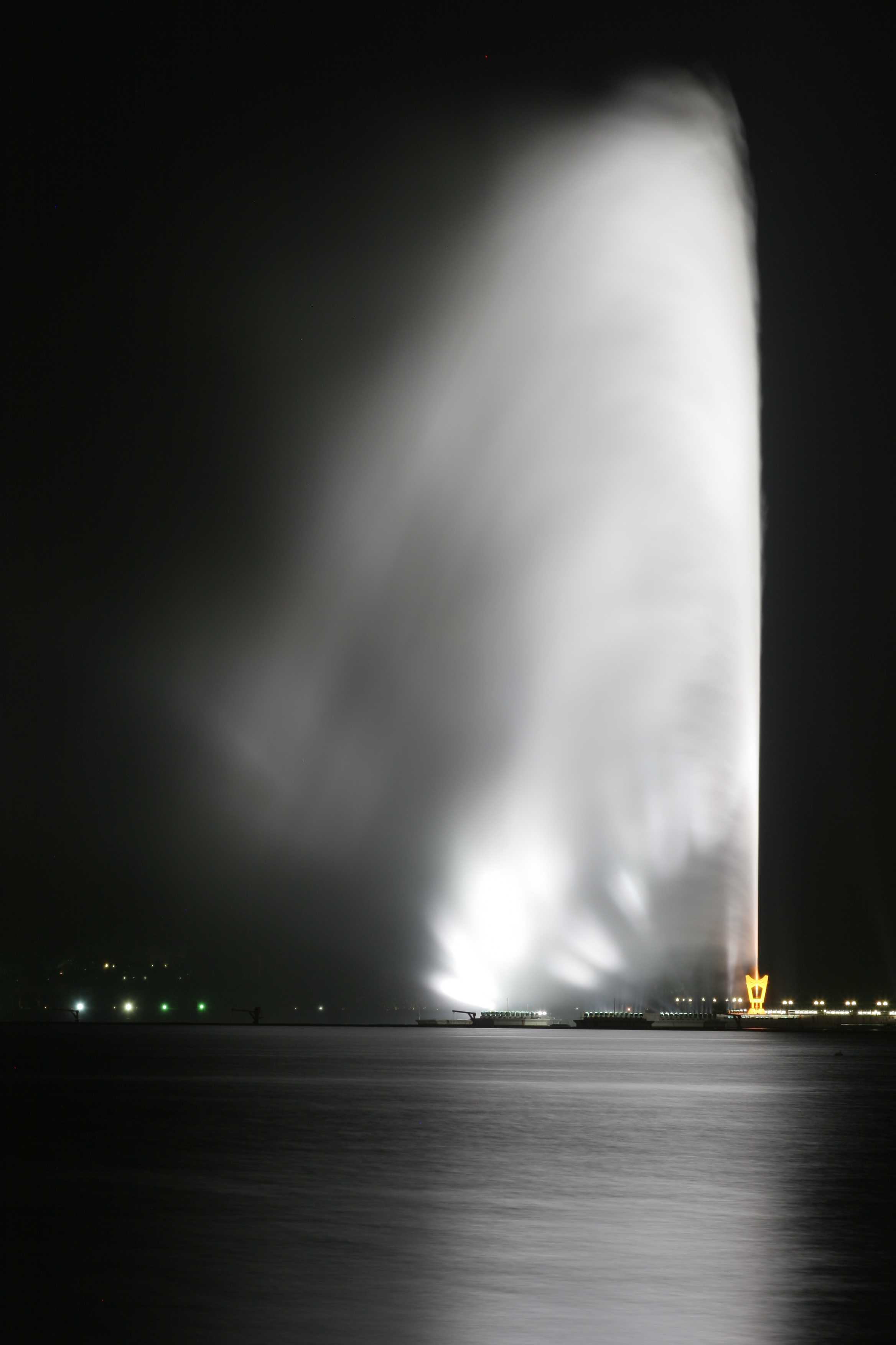 King Fahd Fountain in Jeddah at night, illuminated against the dark sky, shooting water over 300 metres high