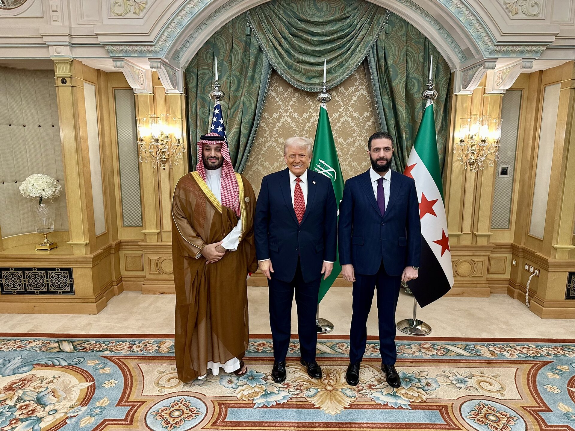 MBS, Trump, and Ahmad al-Sharaa at the Saudi royal palace during Trump state visit, May 2025, with American and new Syrian flags visible
