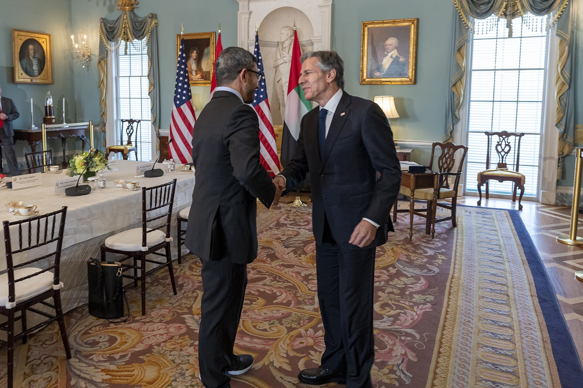 UAE Foreign Minister Abdullah bin Zayed Al Nahyan shakes hands with US Secretary of State Blinken at bilateral meeting with UAE flag displayed