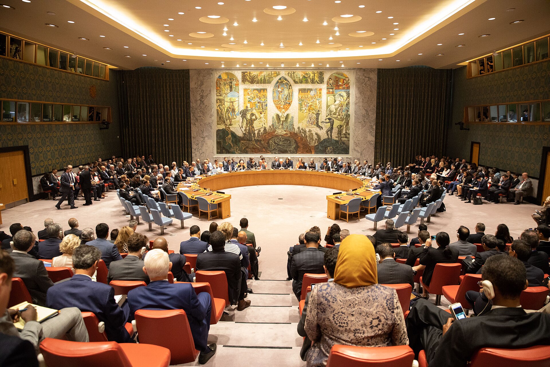 UN Security Council chamber during a high-level open debate, showing the horseshoe table with member state delegates, observer seating, and the Per Krohg mural — the same configuration used for the April 27, 2026 maritime security session on Hormuz