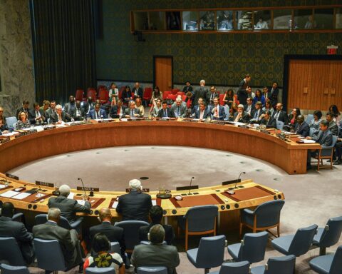 UN Security Council chamber during vote with all 15 member delegations at the horseshoe table, China nameplate visible in foreground