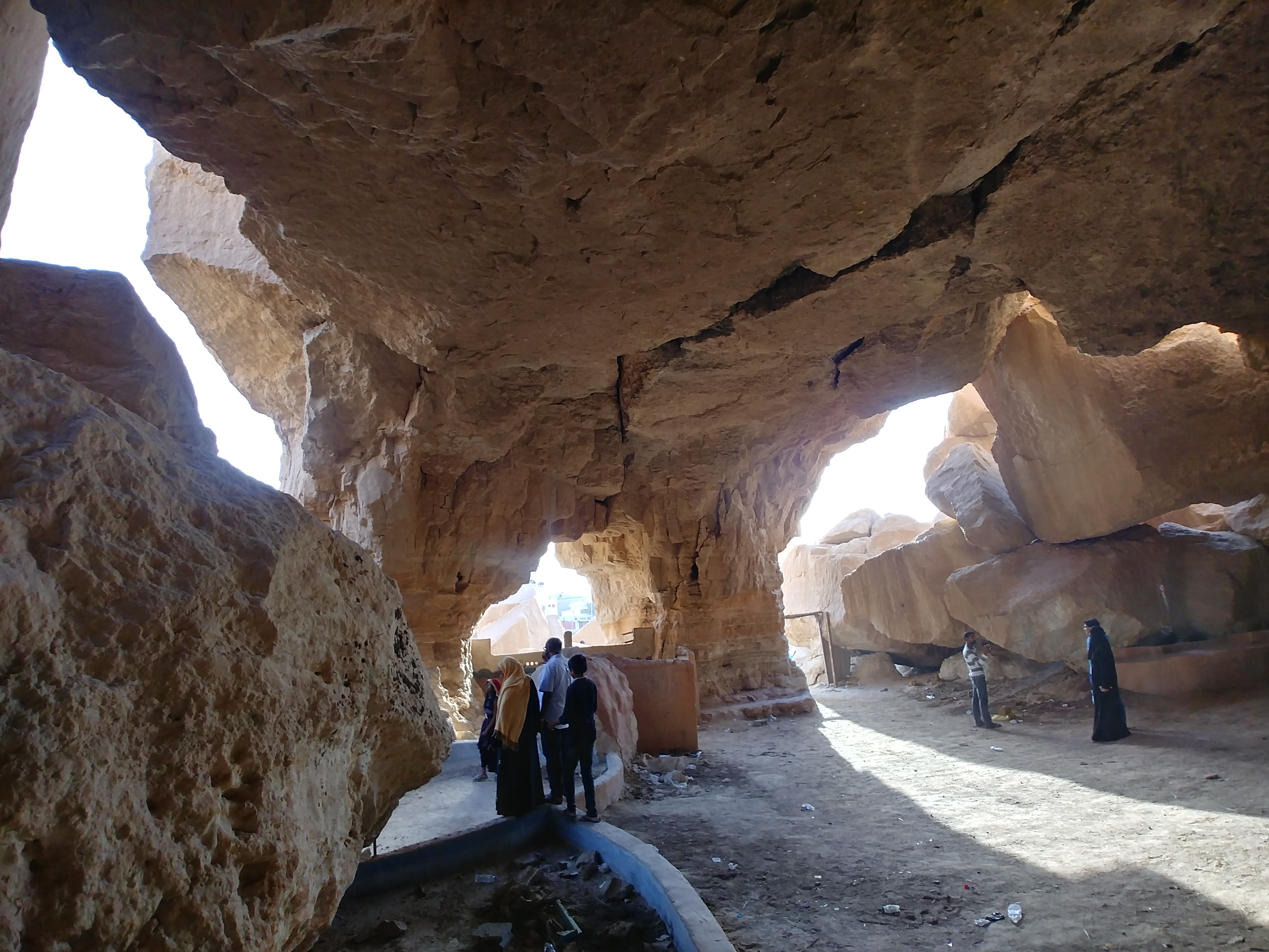 Interior of the natural caves at Jabal Al Qarah showing dramatic wind-eroded rock formations and walkways