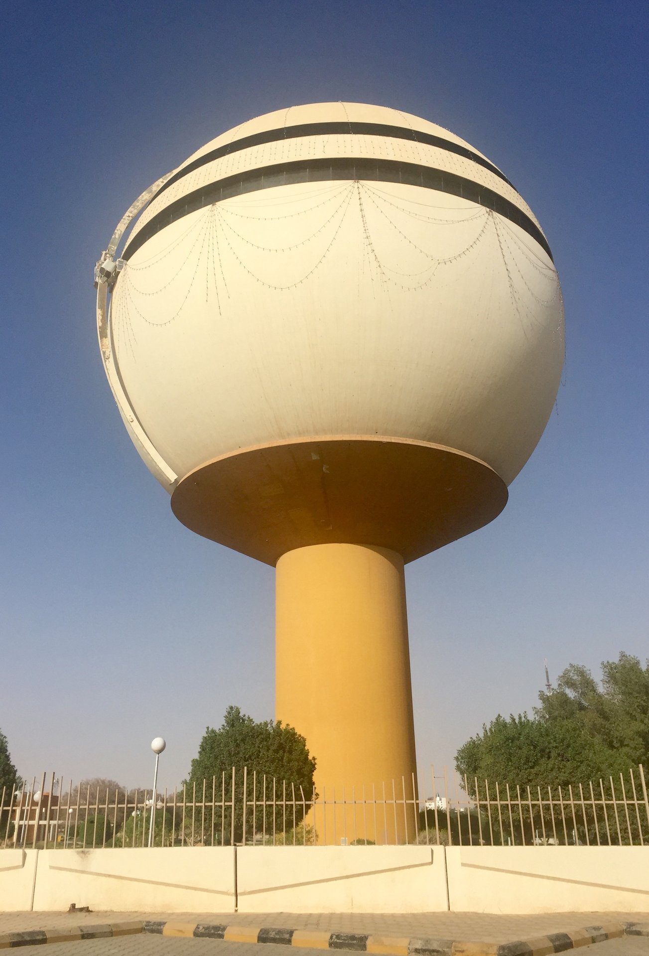 The Buraydah Water Tower, a 66-metre spherical landmark rising over the city skyline against a clear desert sky