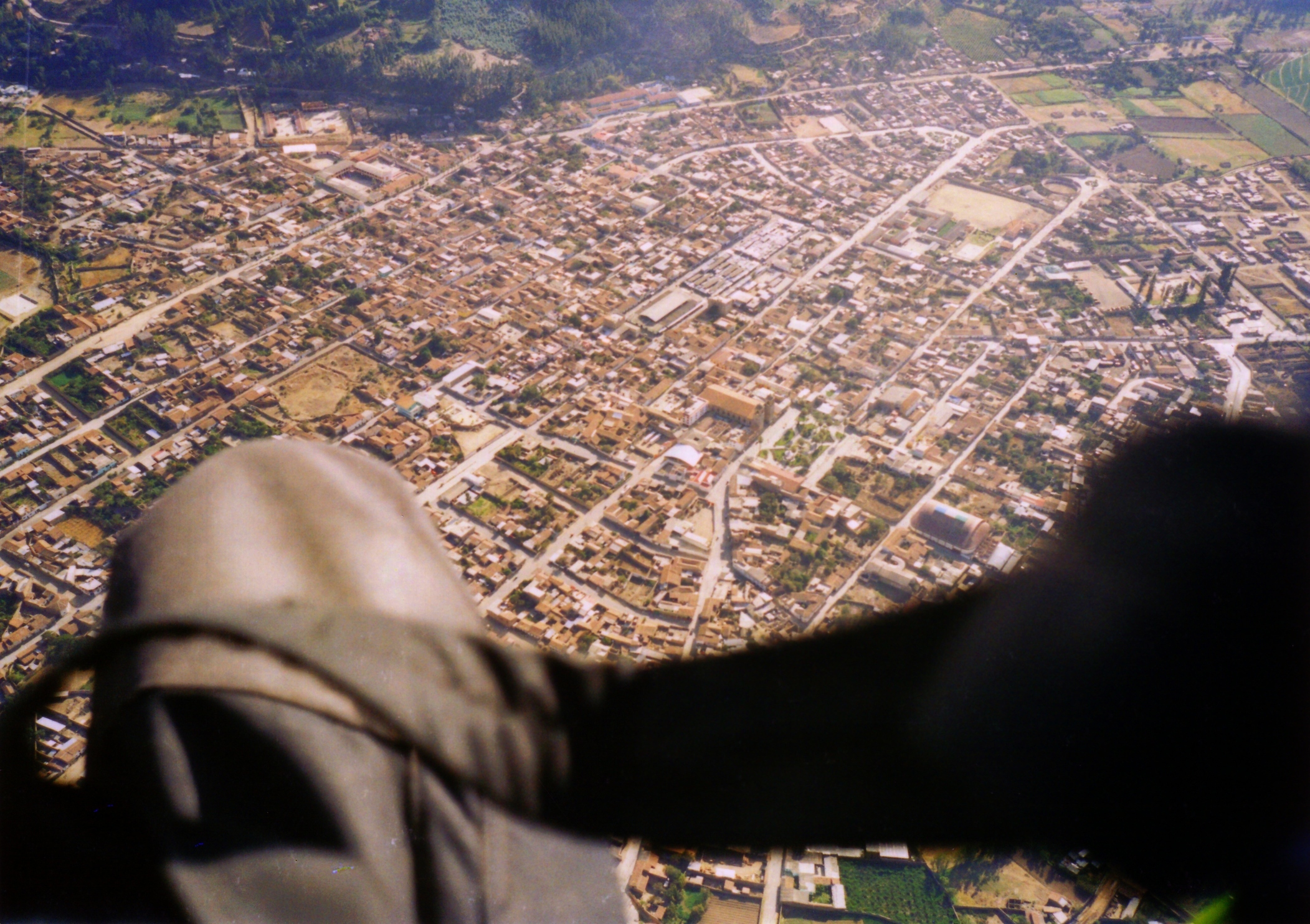 Paraglider soaring above dramatic mountain valley landscape