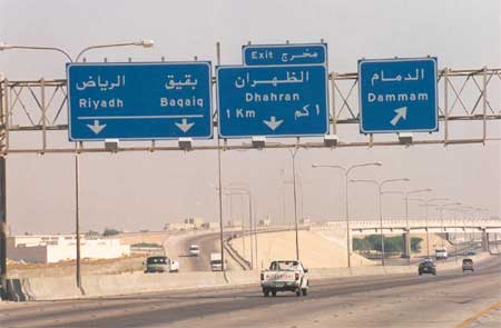 Highway signs showing directions to Riyadh, Dhahran, and Dammam on a Saudi Arabian expressway