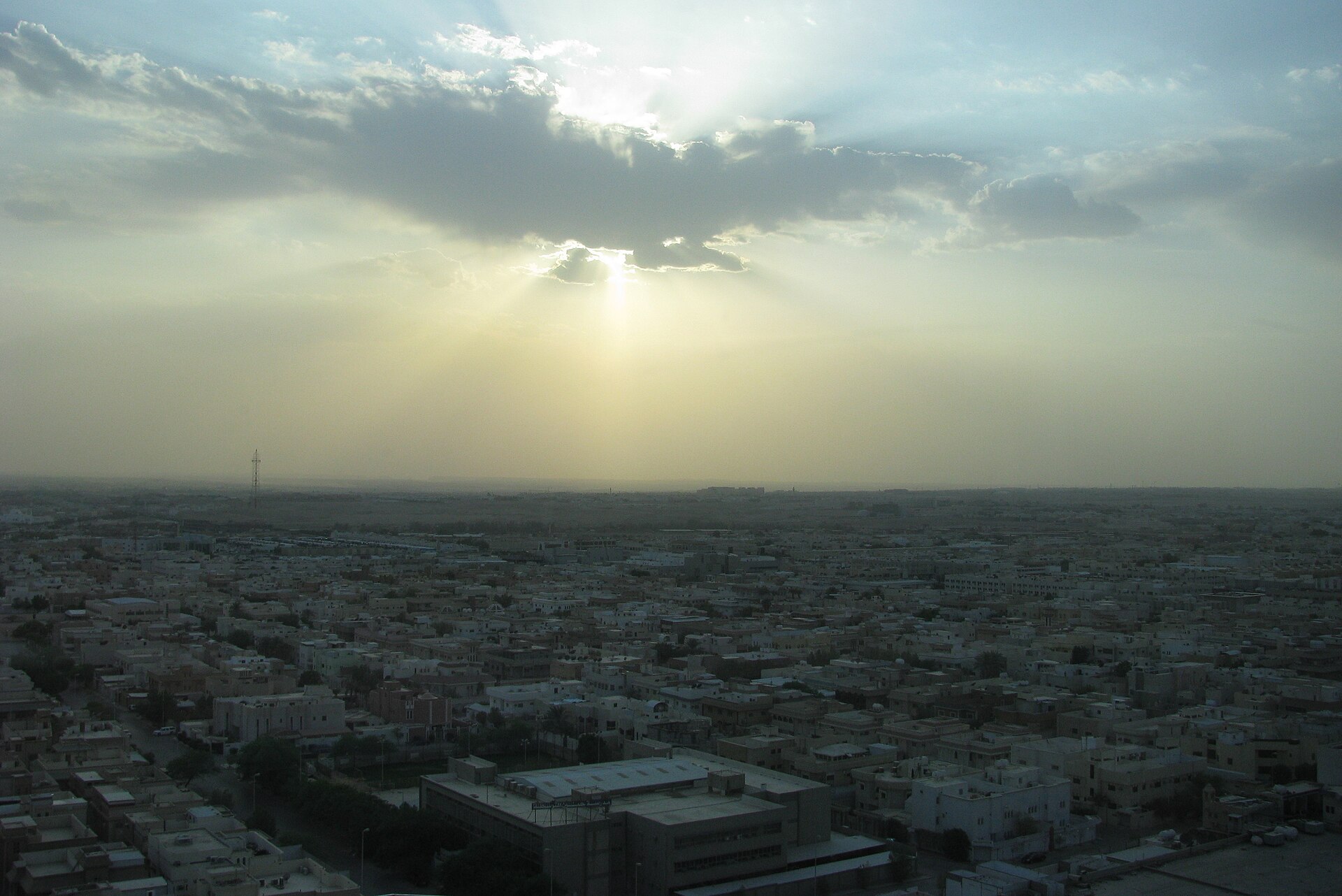Aerial view of Riyadh at sunset showing the city's low-rise neighbourhoods stretching to the horizon