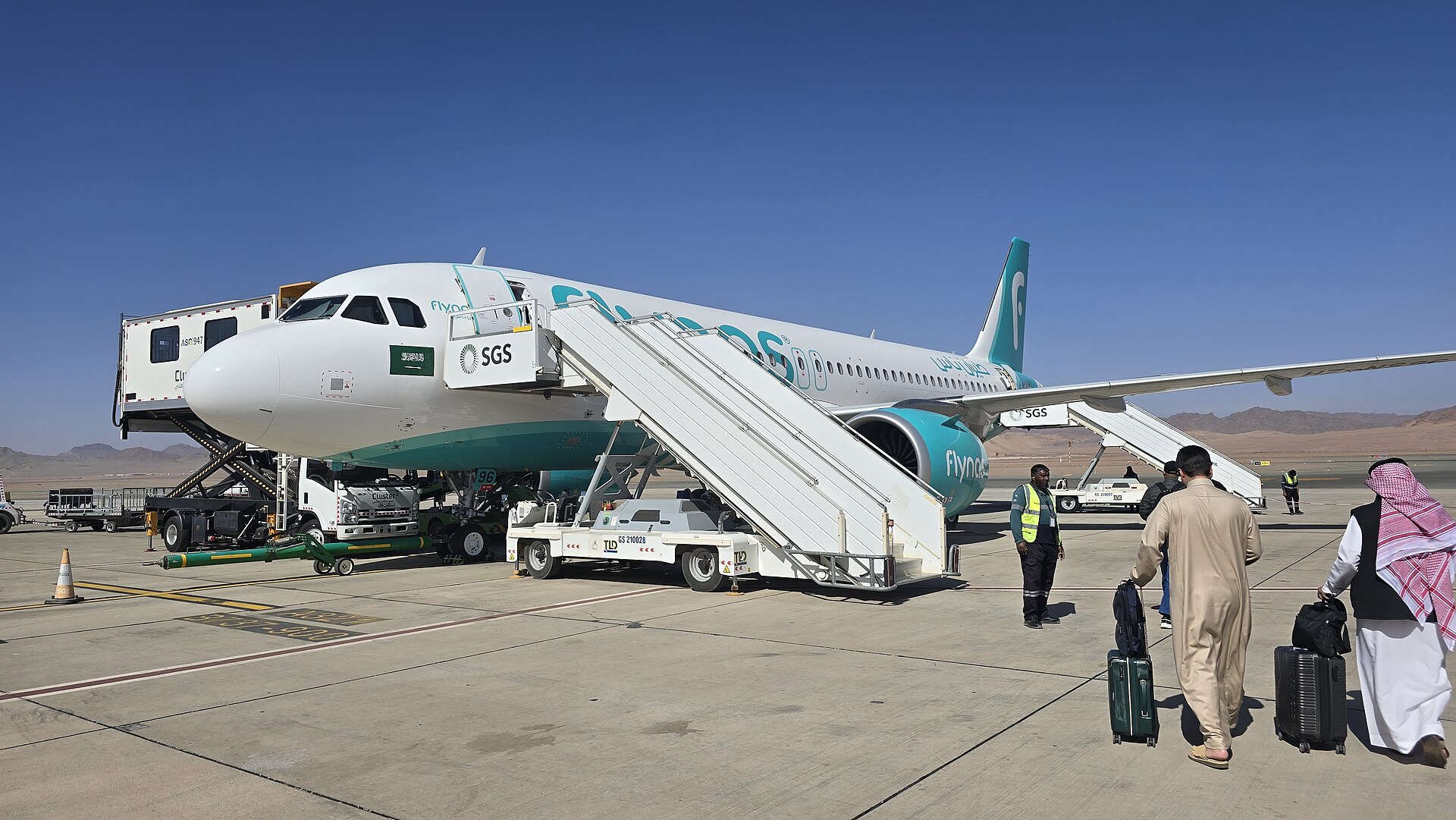 flynas aircraft at AlUla International Airport Saudi Arabia with desert mountains in background
