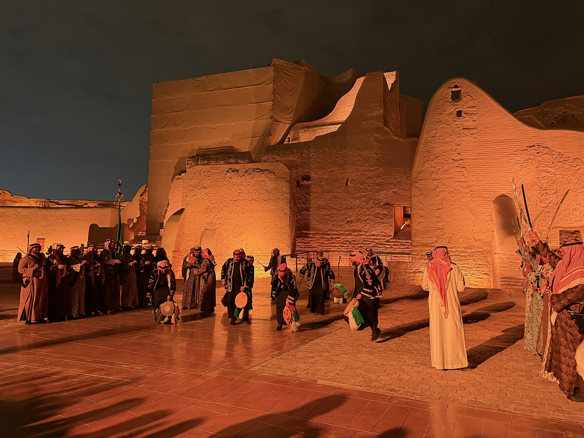 Traditional Saudi Ardha sword dance performed at night in front of Salwa Palace in Diriyah At-Turaif district