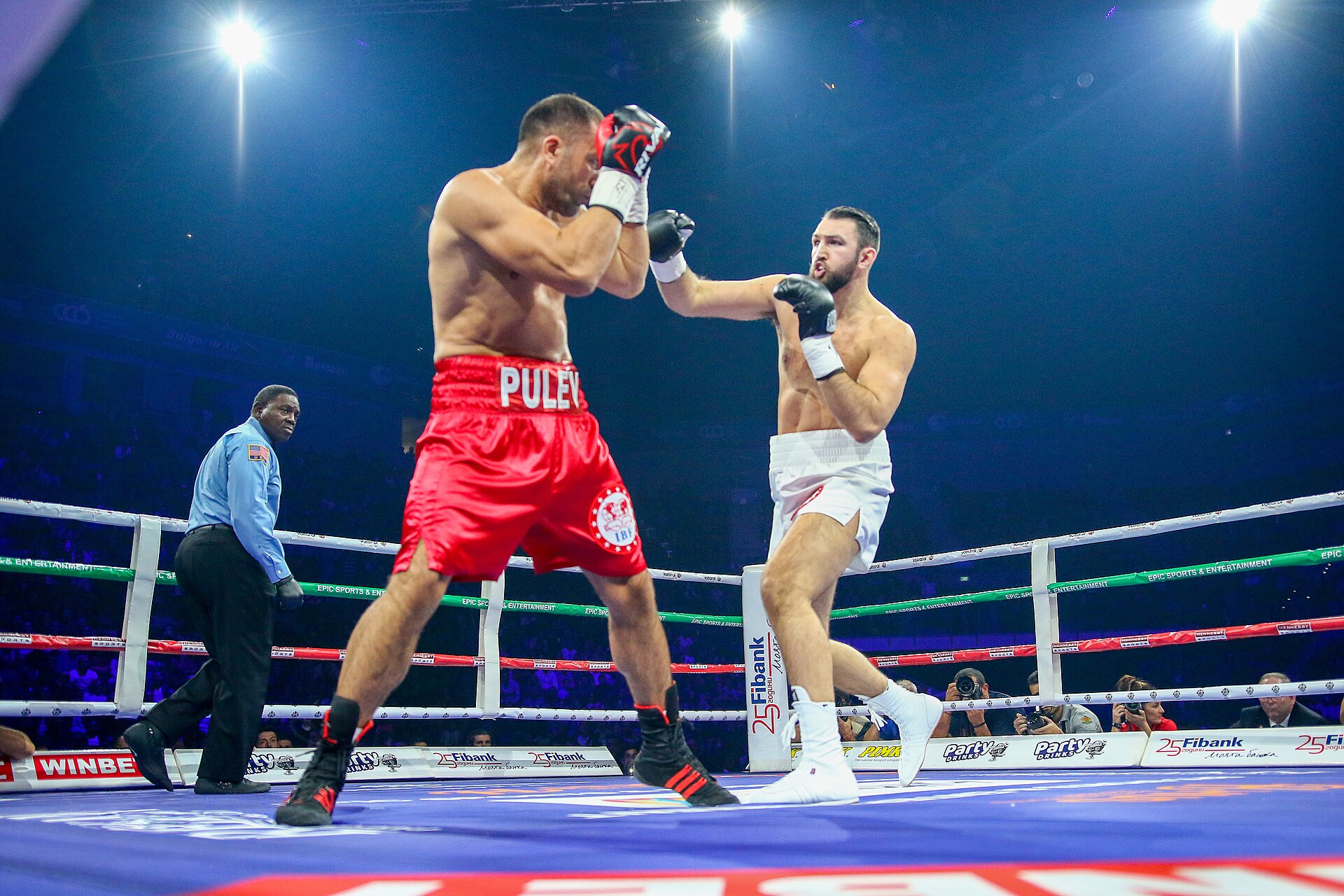 Professional heavyweight boxing match in progress with two fighters exchanging blows under arena lights