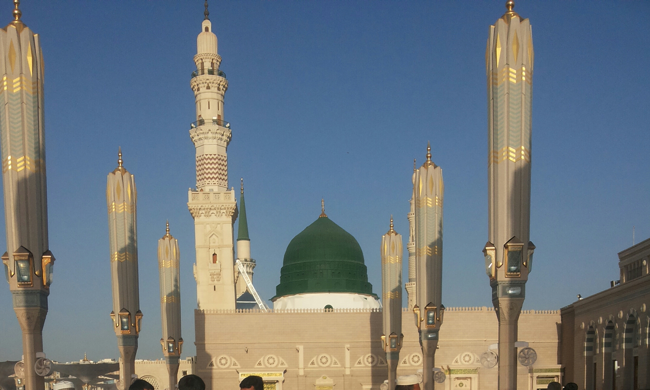 The iconic Green Dome of the Prophet's Mosque rising above the rooftops of Medina at sunset