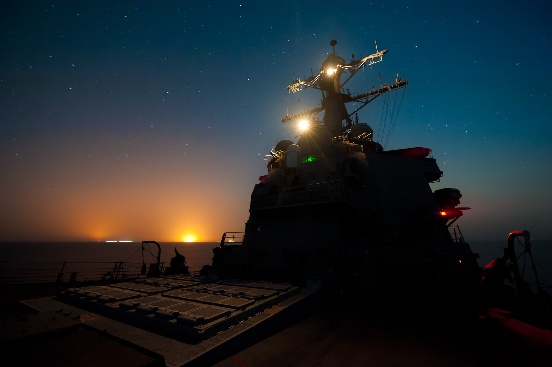 USS Higgins DDG-76 Arleigh Burke-class destroyer patrolling the Arabian Gulf at night — US 5th Fleet destroyers enforce CENTCOM blockade as part of Operation Epic Fury, turning back 23 vessels since April 13