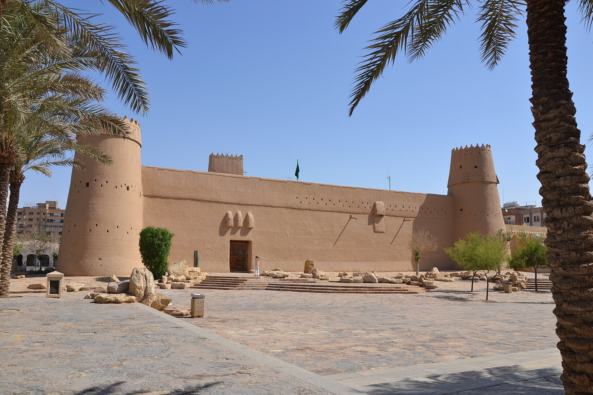Exterior view of Al Masmak Fortress, a mud-brick citadel in central Riyadh with watchtowers and the Saudi flag