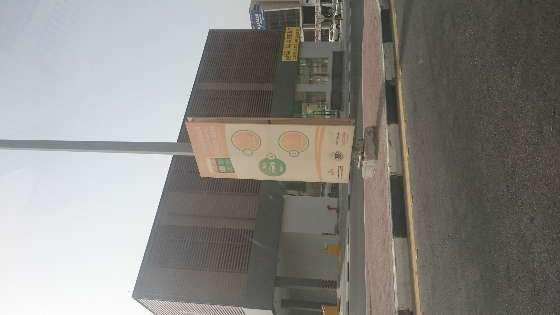 A Najm insurance service officer documenting a car accident at a scene in Khobar, Saudi Arabia