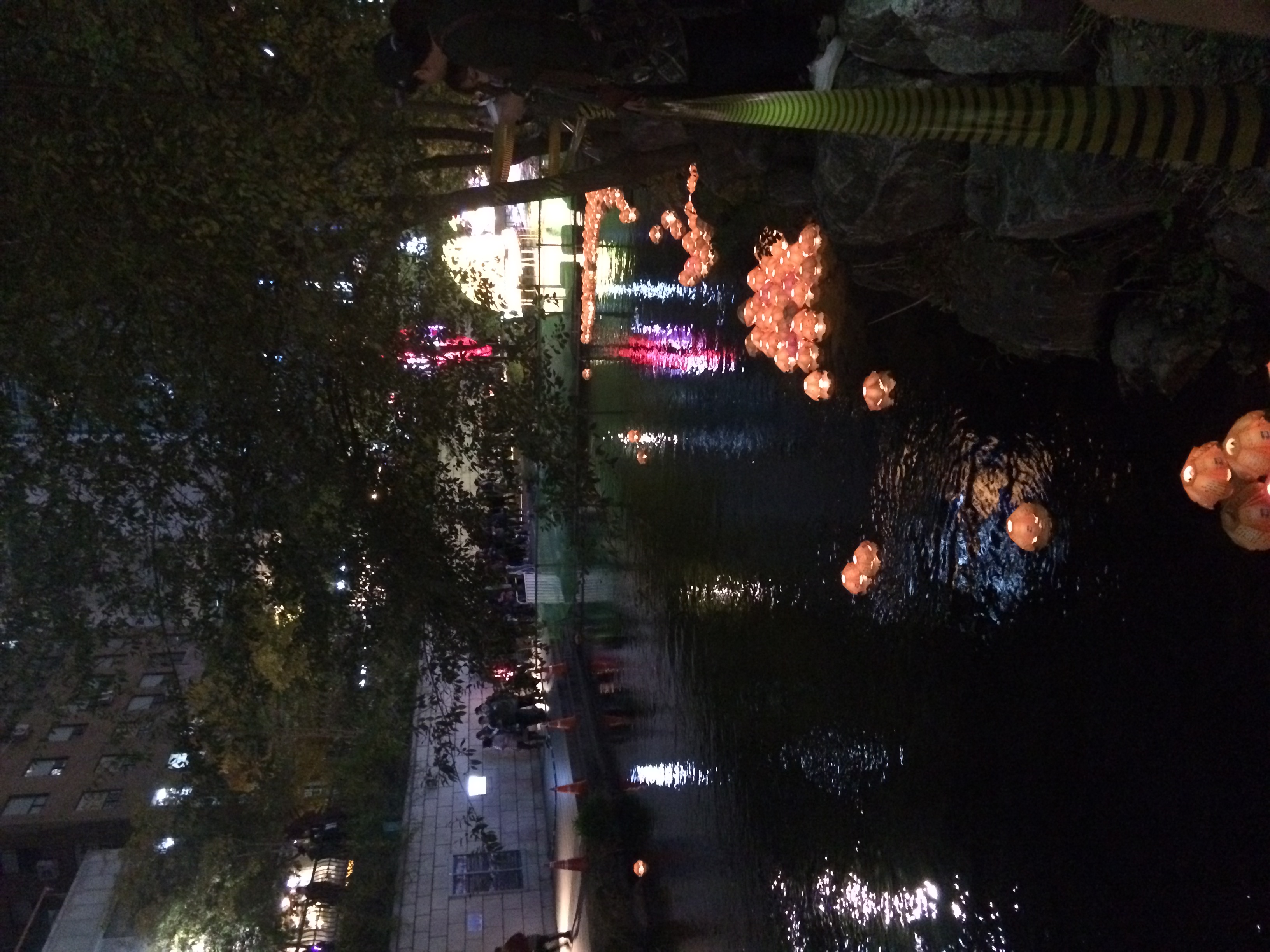 Colourful illuminated lanterns reflected in water at a lantern light festival, similar to the display at Dammam Global City