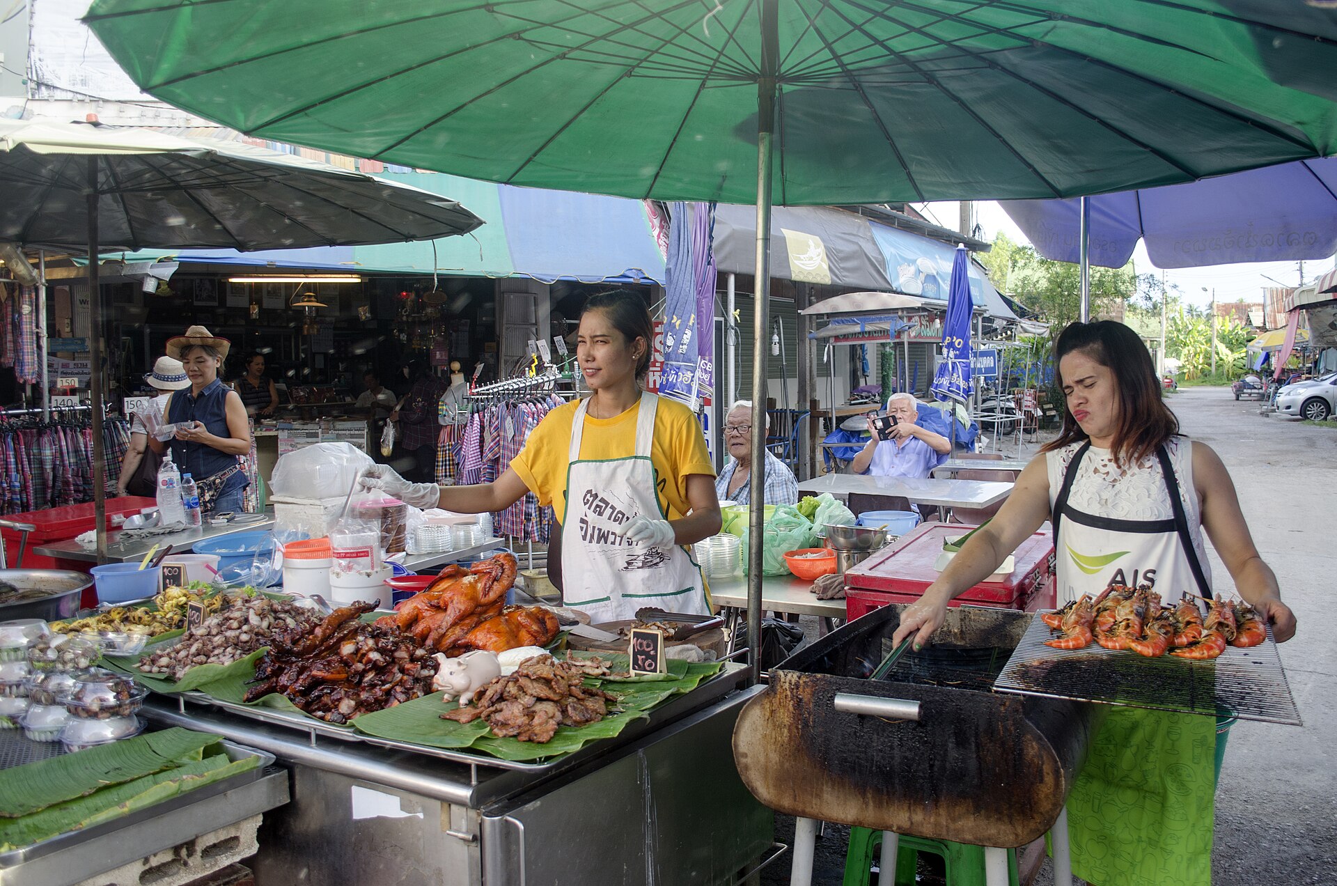 Thai-style floating market food stalls with grilled street food, similar to the waterfront dining at Dammam Global City