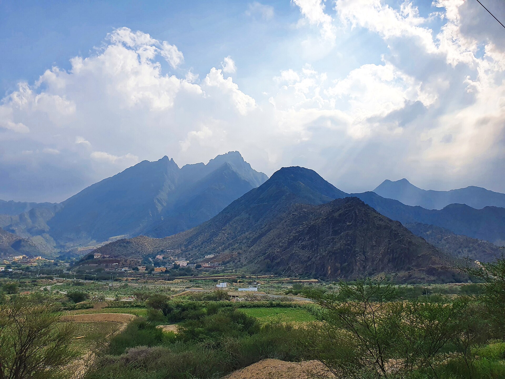 The Sarawat Mountains rising above green farmland in the Al Baha region of Saudi Arabia