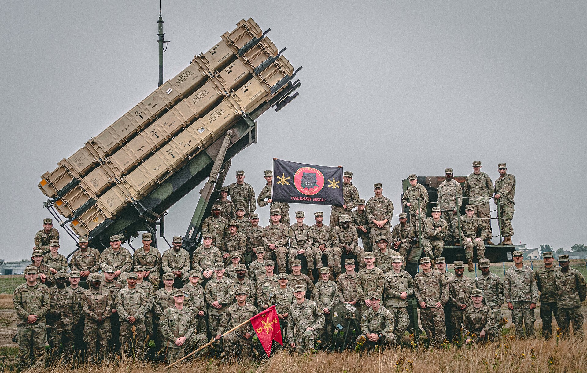 U.S. Army Delta Battery, 5th Battalion, 7th Air Defense Artillery, pose on a Patriot missile launching station in Poland — the same Patriot PAC-3 MSE system protecting Saudi Arabia against Iranian ballistic missiles during Hajj 2026