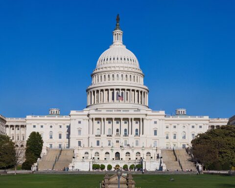 US Capitol building full view with American flag on dome, Washington DC