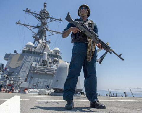 Armed US Navy sailor stands watch aboard a guided-missile destroyer transiting the Strait of Hormuz, May 2023