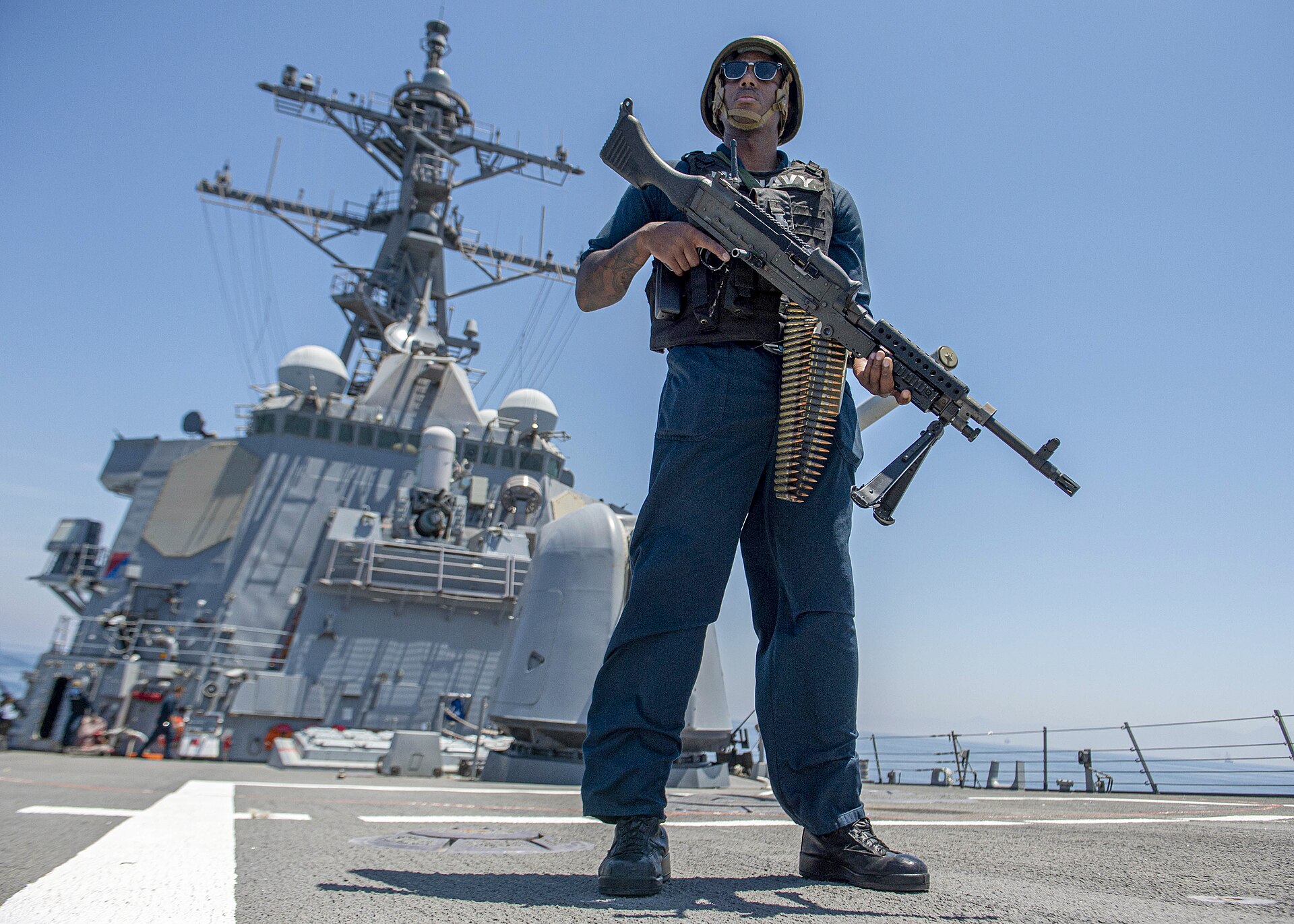 Armed US Navy sailor stands watch aboard a guided-missile destroyer transiting the Strait of Hormuz, May 2023