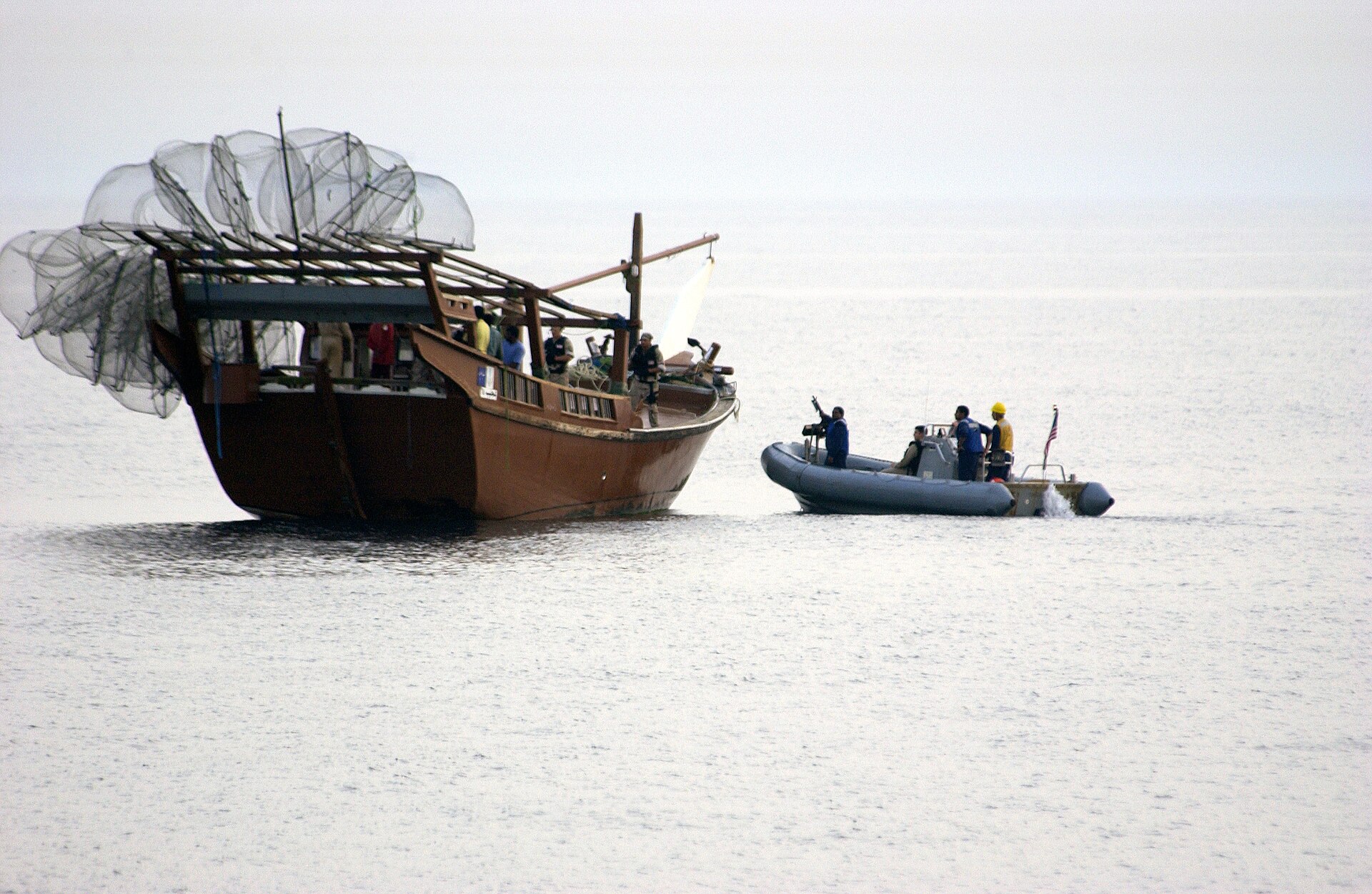 US Navy VBSS team from USS Bulkeley (DDG-84) approaches a dhow in a rigid hull inflatable boat during Maritime Interdiction Operations. VBSS teams conduct visit, board, search, and seizure authority under US Navy doctrine.
